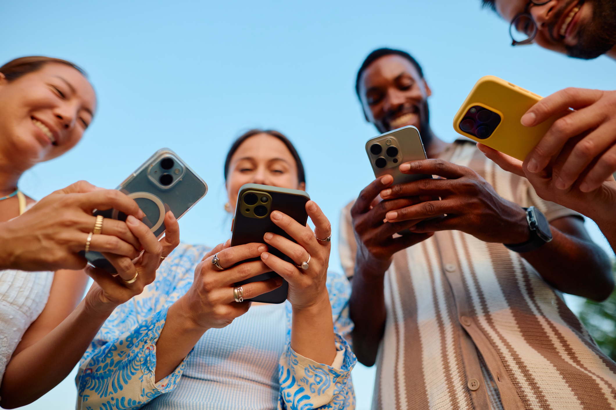 Low angle of people texting outdoors